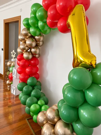 Kırmızı, yeşil ve altın balonlarla birinci yaş kutlaması detayları
