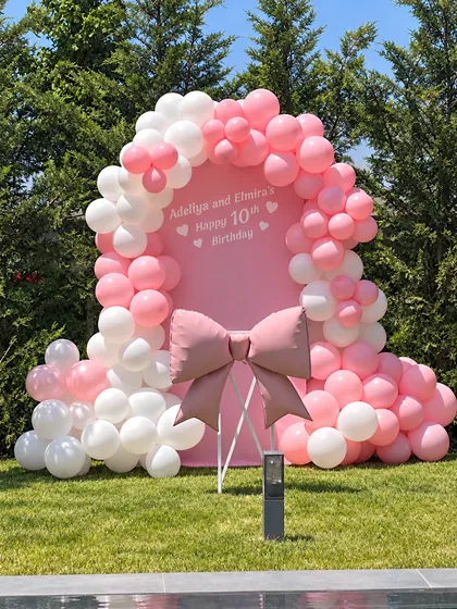 Pembe ve beyaz balonlarla bahçede on yaş doğum günü dekoru