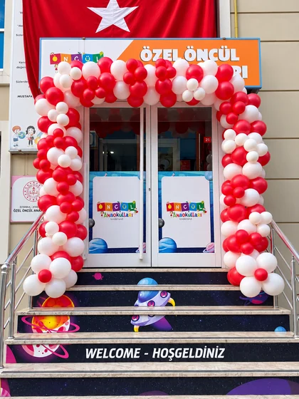 Okul girişinde kırmızı ve beyaz balon kemeriyle hazırlanan açılış süslemesi