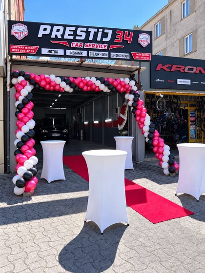 Prestij 34 işletme açılışında pembe, siyah ve beyaz balon kemeri, beyaz bistro masalar ve kırmızı halı